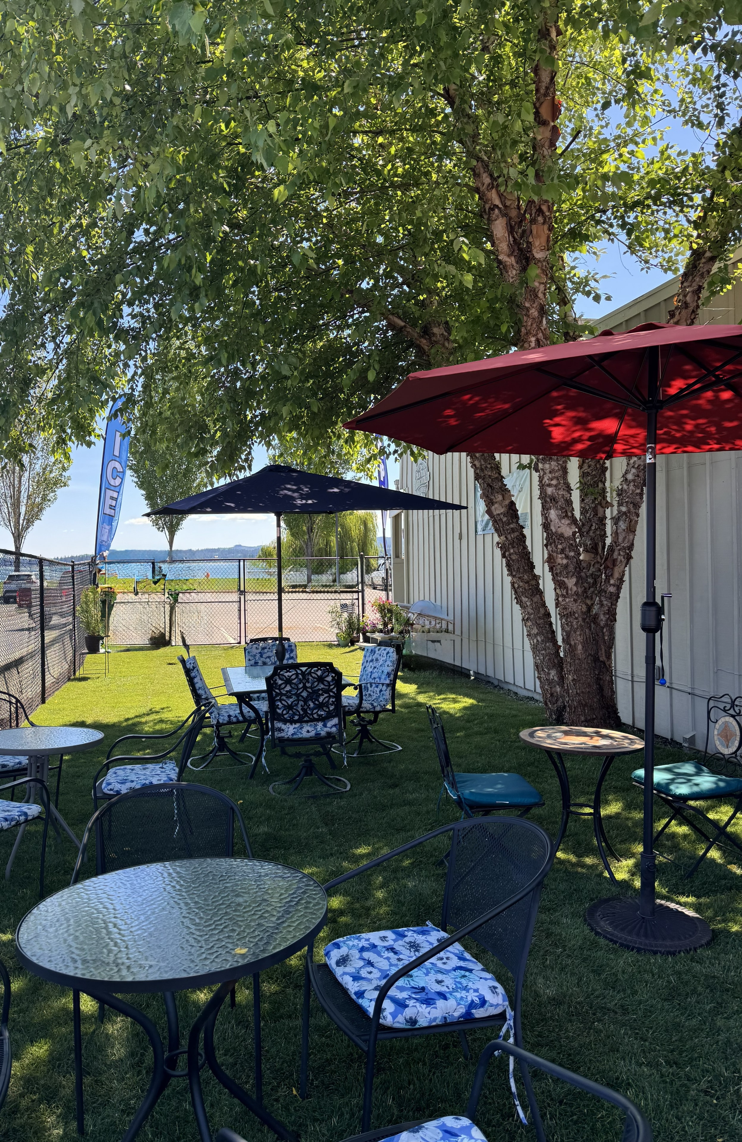 Patio tables and umbrellas in the Byron Street Bites yard