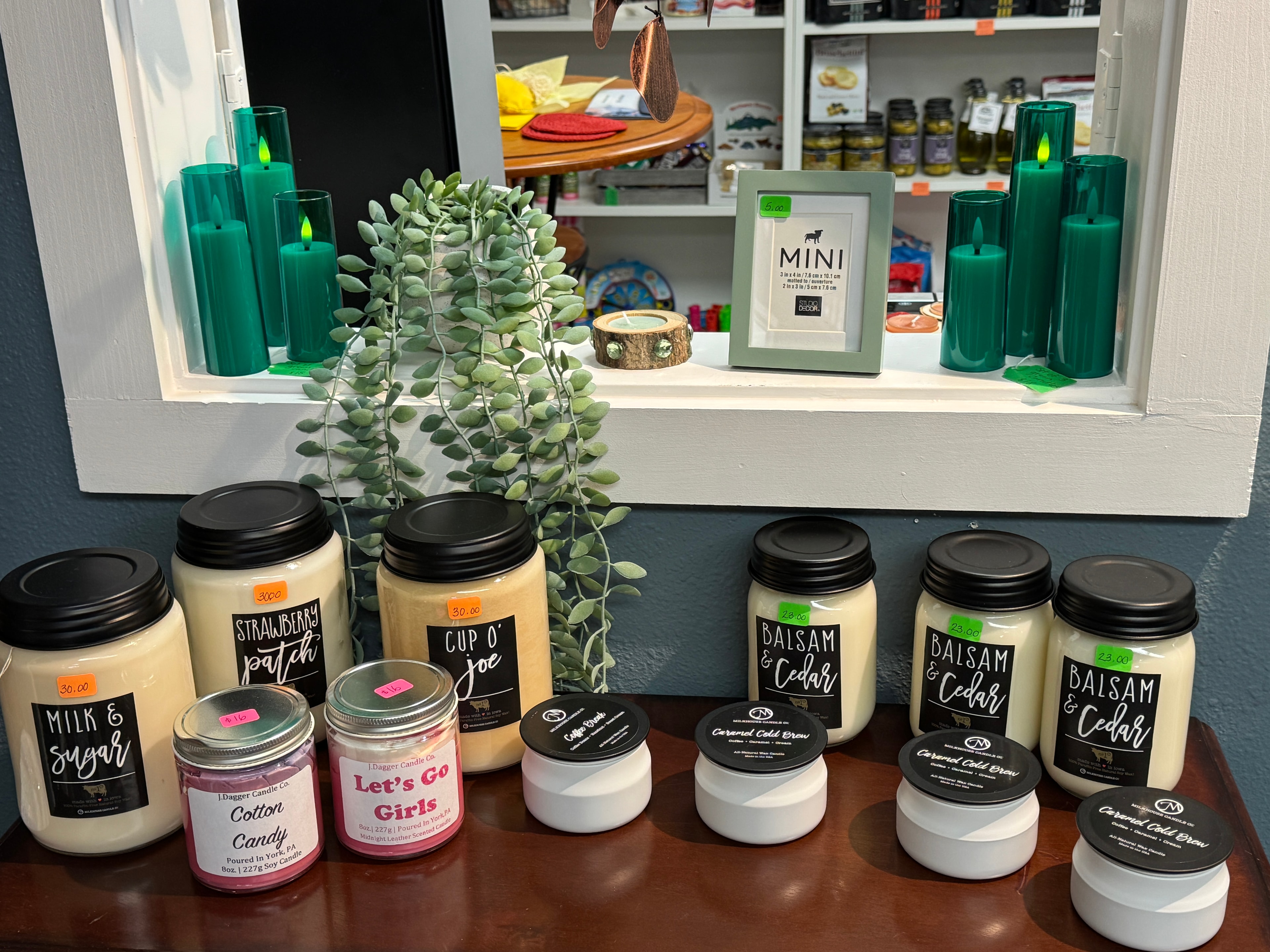 Soy candles and home fragrance display including Balsam & Cedar, Strawberry Patch, and Milk & Sugar scents