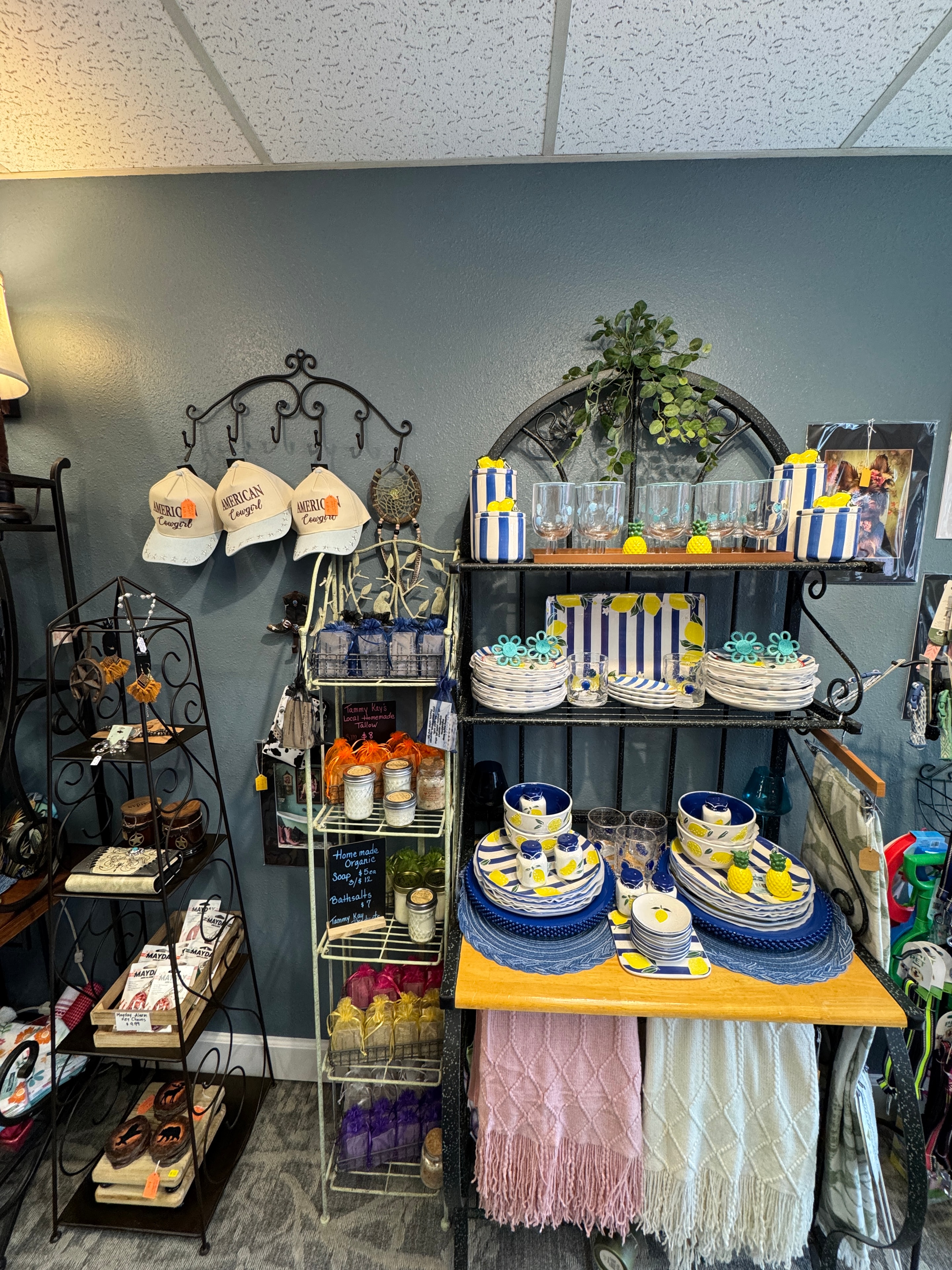 Coastal display with blue and white striped tableware, lemon serveware, hats, and organic soaps
