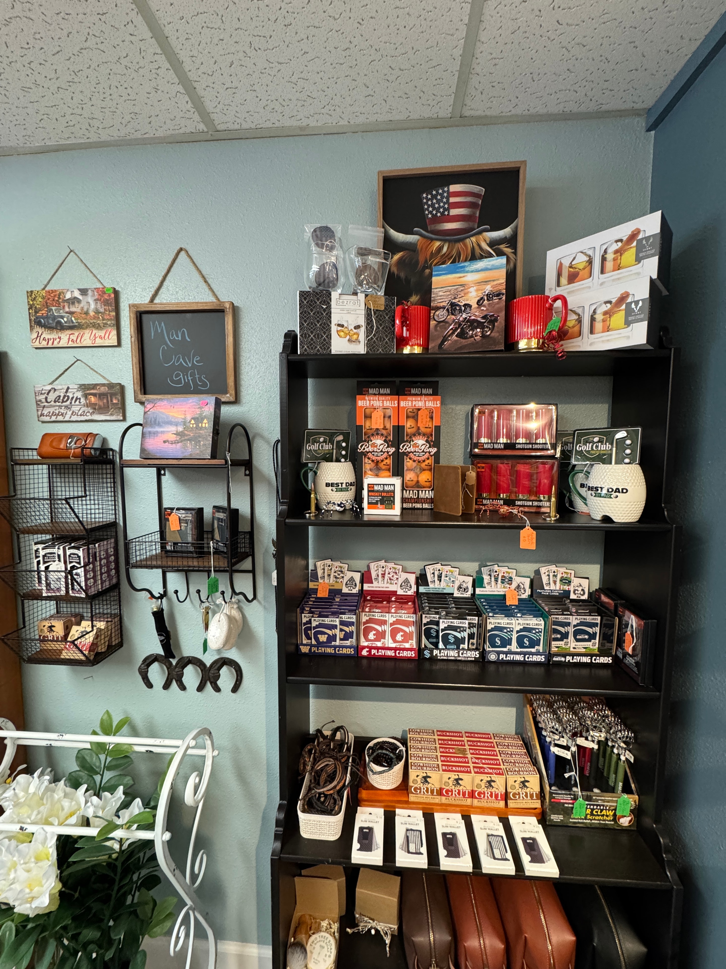 Man Cave gifts shelf with golf mugs, Mad Man novelties, GRIT soap, playing cards, and Man Cave sign