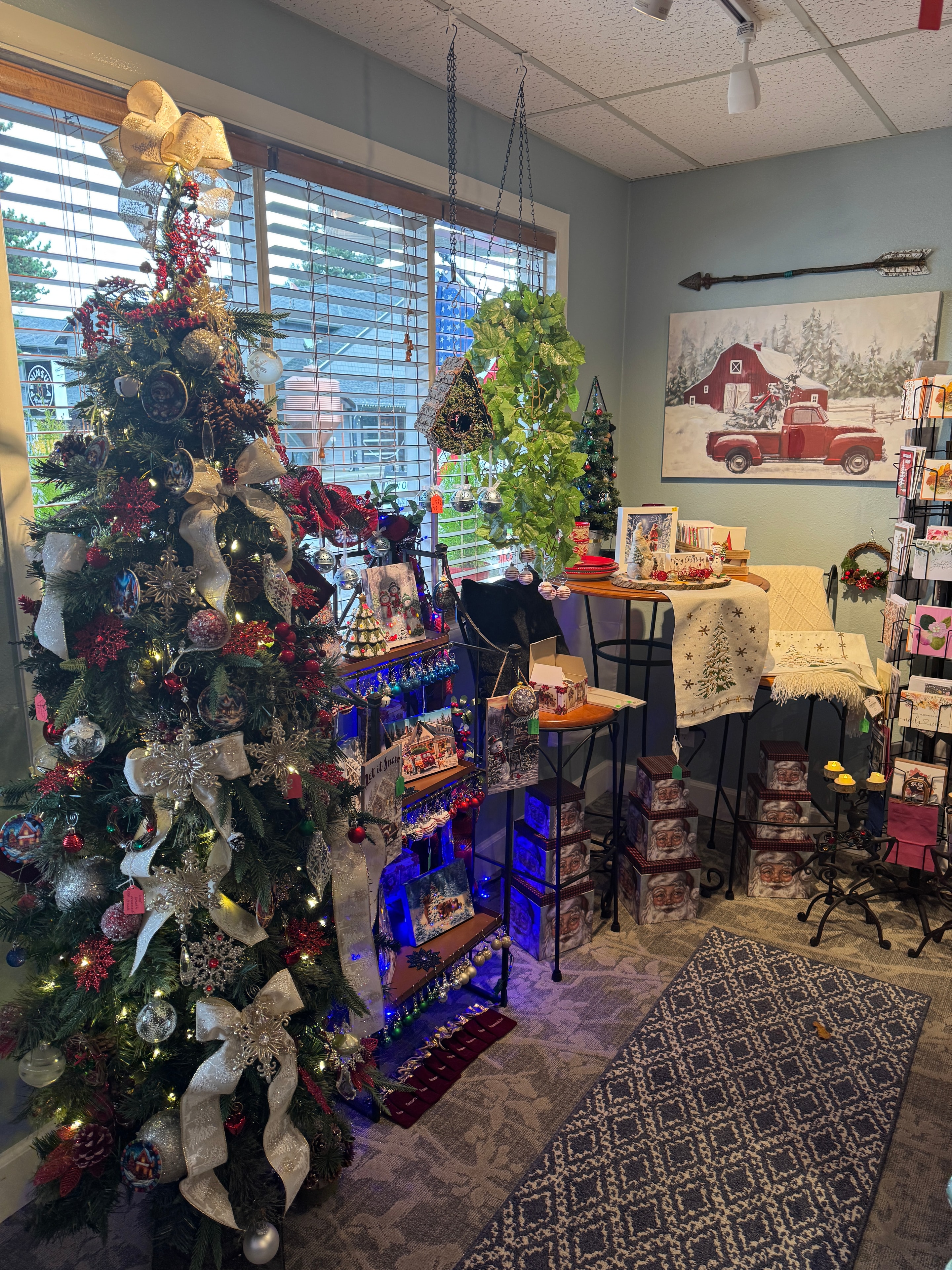 Full Christmas display at Old Town Mercantile with Santas, red church, snowmen, ornaments, candles, and decorated shelves