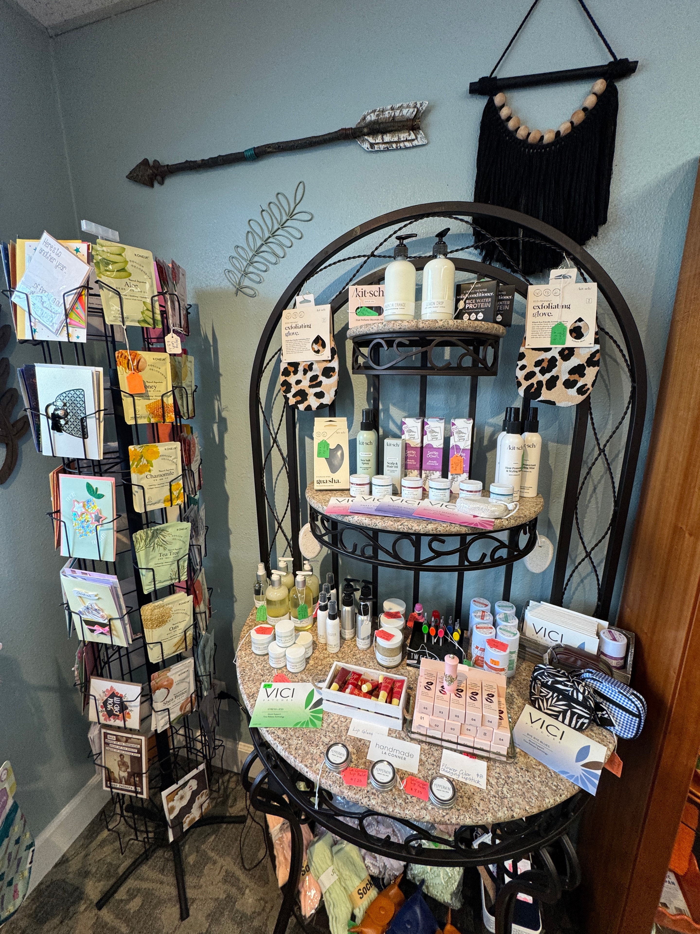 Wellness and beauty display with Kitsch hair care, VICI skincare, exfoliating gloves, and greeting card rack