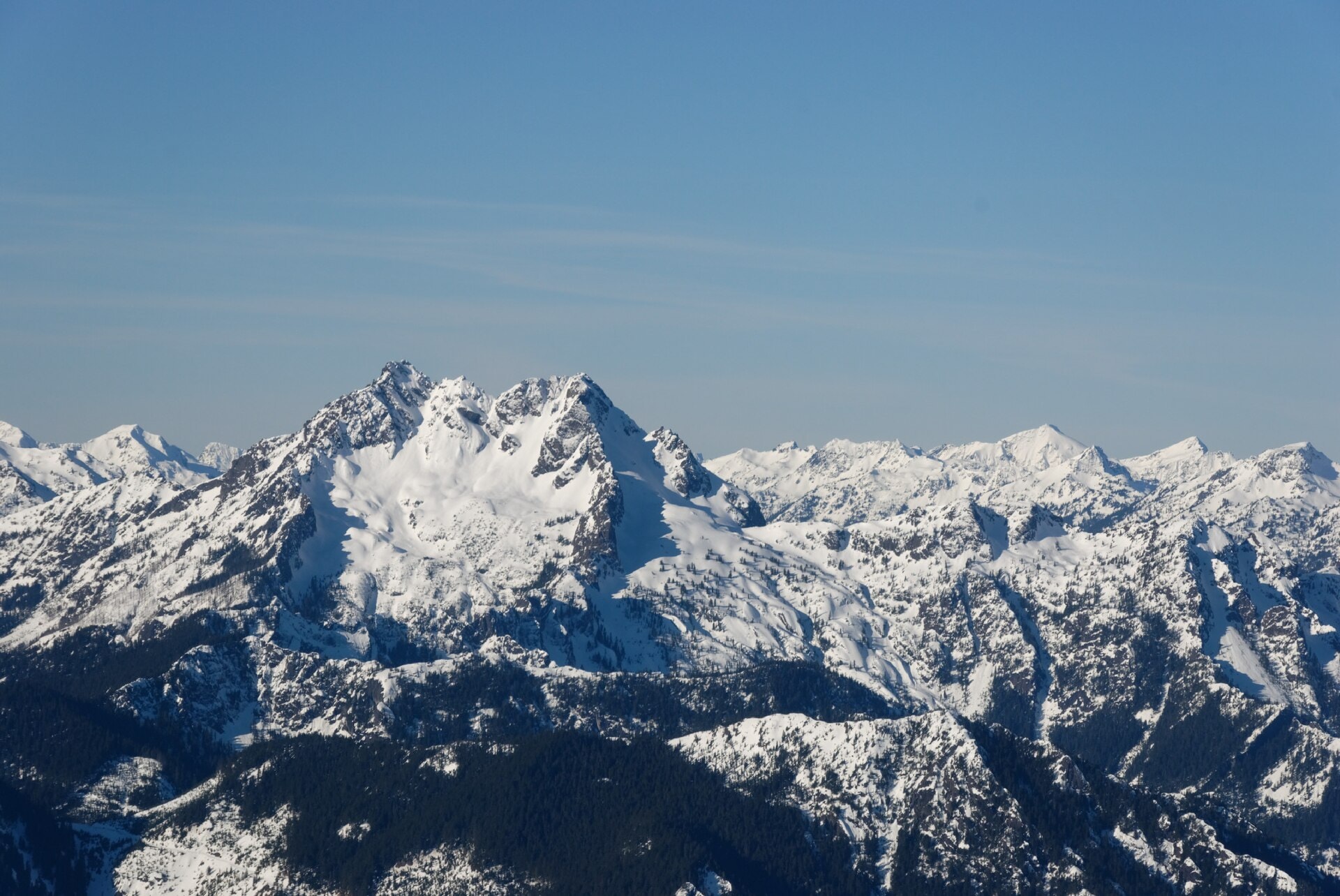 Snow-covered Olympic Mountain peaks under a clear blue sky
